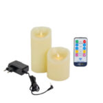 De LED wax kaarsen set 2 maten warm wit oplaadbaar DORSETTO, met zwarte voedingsadapter en afstandsbediening, is afgebeeld op een witte achtergrond.