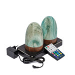 Two Tafellamp DORSETTO oplaadbaar 105 uur, waterdicht, ovaal lampen in marmer groen met houtlook grijs en goud staan op een zwart plateau. De set van 2 wordt geleverd met afstandsbediening en adapter.