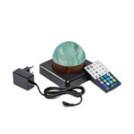 Een ronde, waterdichte Tafellamp DORSETTO oplaadbaar 105 uur in groen marmeren houtlook staat op een zwarte voet naast een voedingsadapter en een kleurrijke afstandsbediening op een witte achtergrond.