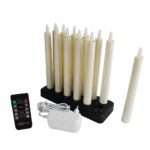 Een set van 12 Dinerkaars 197mm LED DORSETTO oplaadbare kaarsen (130 uur warm wit) staat op een zwarte oplaadbasis met afstandsbediening en witte adapter; één kaars wordt apart geplaatst.