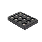 Een zwart rechthoekig Oplaadstation zwart magnetisch DORSETTO (voor 12 theelichtjes) met twaalf ronde magnetische sleuven, elk met een metalen contactpunt, tegen een witte achtergrond.