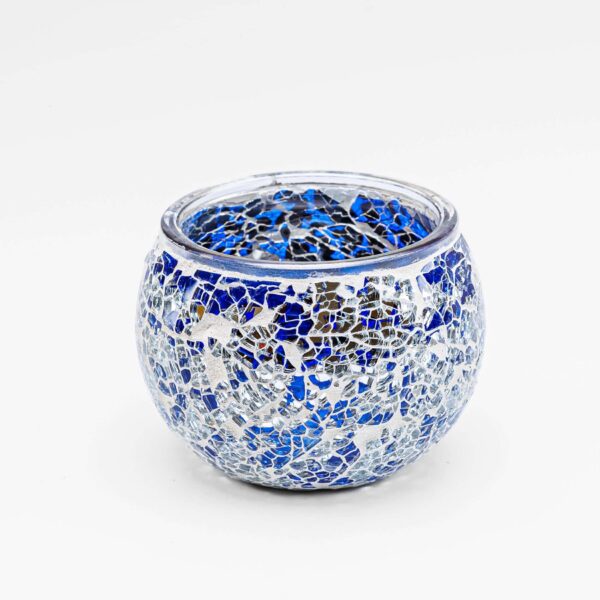 De Theelichthouder 9 cm DORSETTO donker blauw is een ronde glazen kandelaar versierd met een mozaïekpatroon van donkerblauwe, zilveren en heldere stukjes tegen een witte achtergrond.