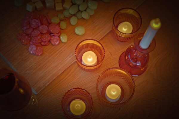 kaarsjes in glazen houders bij een borrelplank