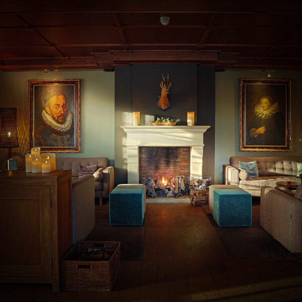 openhaard met schilderijen aan de muur in een woonkamer.