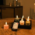 Zes oplaadbare waxinelichtjes in meerdere kleuren met tot 250 uur licht en een afstandsbediening staan op een houten tafel, terwijl de achtergrond sfeervol vervaagd is.